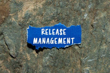 Release Management message written on ripped torn blue paper on stone background. Conceptual...