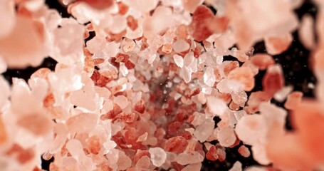 Himalayan pink salt is fallingin a super slow motion. Pink Himalayan salt is up to twenty times more expensive than table or sea salt. Shot on super slow motion camera 1000 fps.