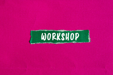 Workshop message written on ripped torn green paper piece on pink background. Conceptual Workshop...