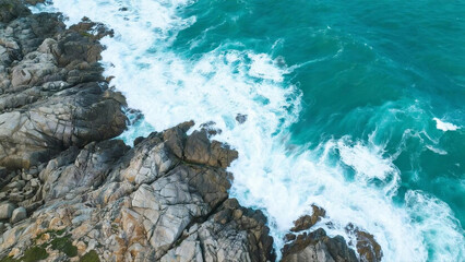 Aerial View of Turquoise Ocean Waves Crashing on Rocky Coastline