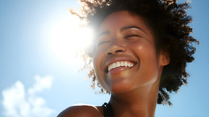 Young woman smiling with eyes closed under the sun
