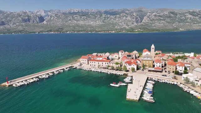 Aerial footage of Vinjerac village and its harbor with boats along the Adriatic coast
