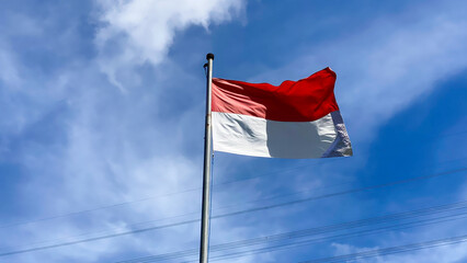Indonesian Flag, The Red and white Flag, national symbol of Indonesia on the top. isolated blue sky background. Good structure for using background needed or independence day