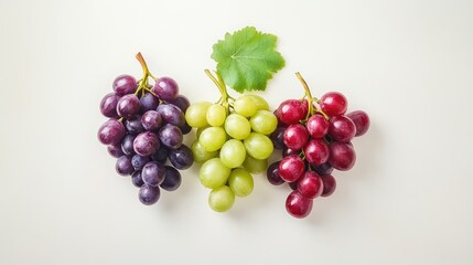 Fototapeta premium Grapes in contrasting colors--emerald green, rich red, and dark purple--styled neatly on white surface for a crisp fruit layout