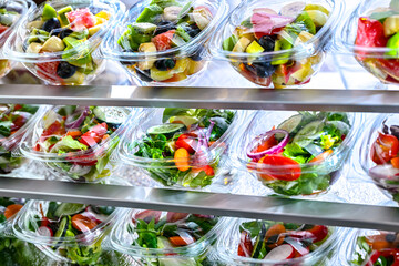 Boxes with fruit and vegetable salads in a commercial fridge