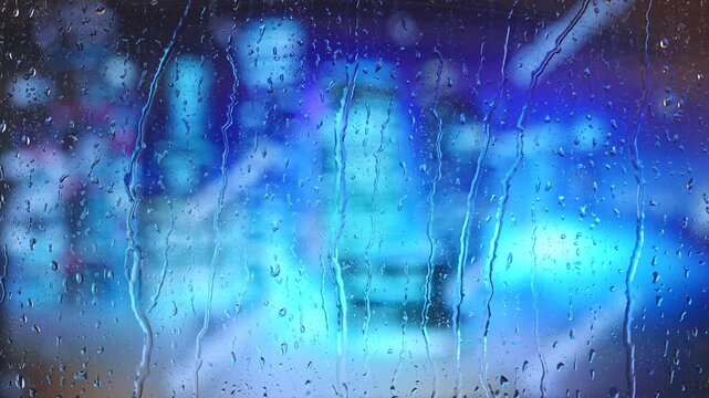 Rain drops on window with blurred cityscape and blue sky