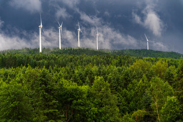 Wind turbines in the clouds over a mountain