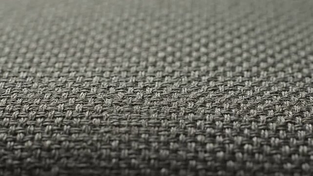 Closeup of woven fabric with a repeating pattern of interlaced gray threads