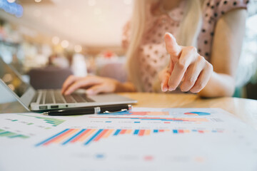 Fototapeta premium Business concept. Businesswoman Analyzing Data on Laptop with Charts Displayed