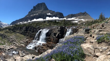 Mountain Waterfall with Blue Wildflowers and Snowcapped Peak