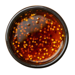 Overhead shot of flavorful chili oil with seeds in a bowl offering an authentic taste Isolated on transparent background