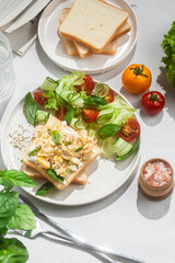Scrambled eggs on toast bread with cucumber, tomato and herbs.White background.Healthy breakfast