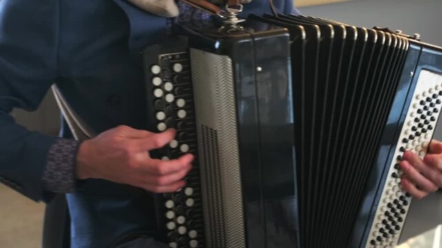 Close-up of an unidentified musician playing the accordion, instrument, the performer hands, and the motion of the bellows. Face out of frame, creating a universal and neutral educational shot.
