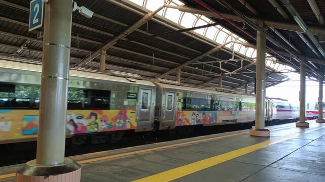 An electric rail train passes a long-distance train at a station in Jakarta. Jakarta, Indonesia - July 20, 2025.