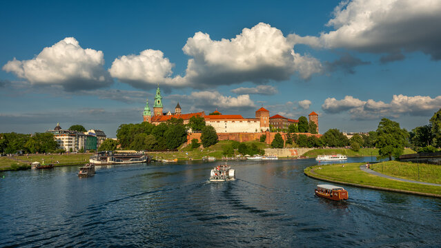 Krak&oacute;w. Wawel i Wisła z barkami, w tle niebieskie niebo z chmurami w lecie