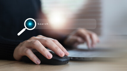 Close-up hand using a mouse with an AI search icon on a virtual screen. Concept of artificial...