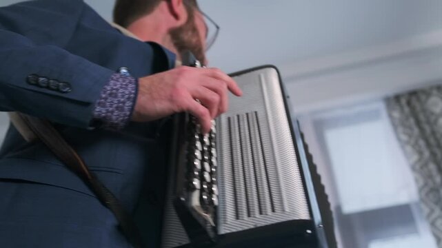 Seen from a dramatic low angle, a young poet-musician plays the accordion, passionate expression and artistry, capturing the poetic energy of a solo performance in a cozy setting.