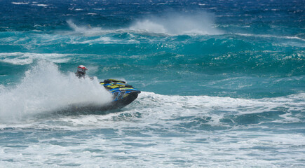 Pilot riding jet ski making splash in ocean waves