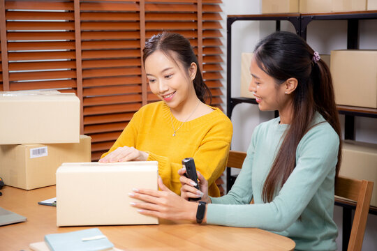 Two young asian woman working while planning online business and checking order with writing on paperwork at home, retail with online seller, startup business and cargo, shipping and service.