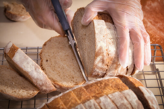 The Moment of Slicing Bread with a Knife on a Cooling Rack - Powered by Adobe