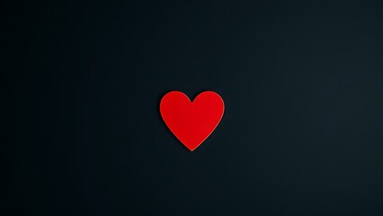Minimalist red heart on dark textured background with directional lighting