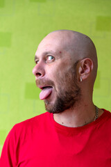 A man poses against a wall, making various grimaces