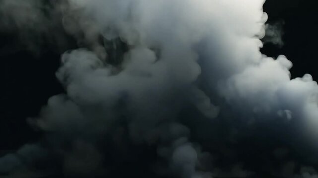 Smoke rising from chimney blending with clouds in a blue sky with foggy and stormy atmosphere