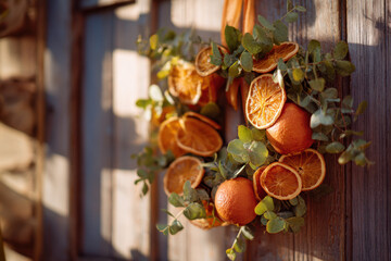close-up of vibrant orange and eucalyptus wreath on rustic wooden door, dried citrus fall decoration in soft afternoon light, seasonal natural decor for autumn lifestyle, eco-friendly holiday vibe