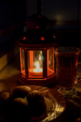 Cozy Candle Lantern with Tea and Traditional Sweets in Warm Light