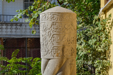 Ottoman Tombstone with Arabic Calligraphy and Turban Motif in Garden Setting