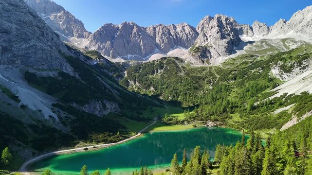 Aerial drone view of the Alps and the green Drachensee on a sunny summer day. 