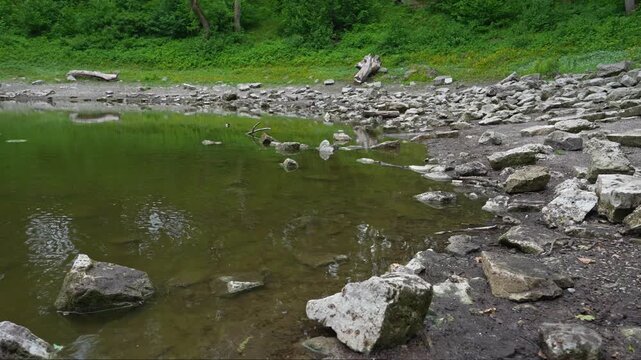 Scenic meteorite crater lake Kaali surrounded by forested terrain.