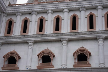 Obraz premium Classical European Facade with Arched Windows, Ornate Columns, and Pink Accents