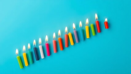 Colorful birthday candles arranged in a straight line against a solid blue background.
