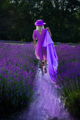 A person in a vibrant pink dress and hat walks through a lush lavender field, leaving a shimmering purple trail behind. The vivid colors contrast