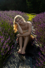 lavender, field, woman, smiling, sunlight, nature, flowers, peaceful, serene, joyful with sunlight gently illuminating her and the surrounding flowers. Her relaxed posture 