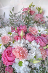 A beautiful bouquet of different flowers. Roses, carnations, daisies of white and pink color with green leaves. High quality photo