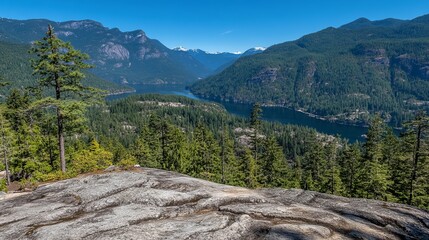 Panoramic view of a serene lake nestled within a majestic mountain range, showcasing lush greenery and rocky terrain from an elevated vantage point