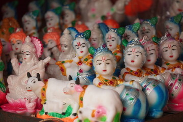 Several god idols are displayed for sale in a market 