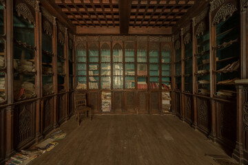 Abandoned vintage library room with ornate wooden shelves and scattered old books in a decaying French chateau