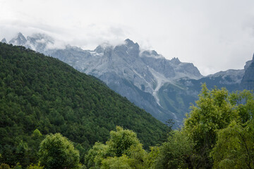 Obraz premium A Scenic View of Mountain Forests Enveloped in Mist and Clouds