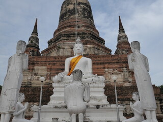 A pristine Buddha and devotees before Ayutthaya's ancient chedi. A powerful scene showcasing...