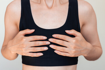 Young woman in black underwear holding her small breasts with both hands. Women's Health