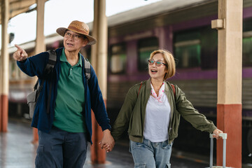 Mature couple waiting together at train station for journey
