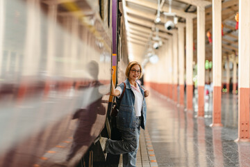 Mature woman awaiting her journey at train station platform