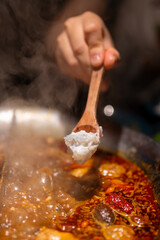 A Delicious Moment in Hot Pot: Scooping Tofu from the Boiling Broth