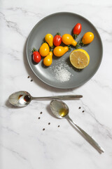 Summer salad ingredients - Freshly harvested cherry tomatoes, spoon of vinegar and olive oil, salt and pepper