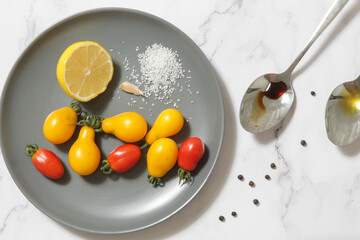 Summer salad ingredients - Freshly harvested cherry tomatoes, spoon of vinegar and olive oil, salt and pepper