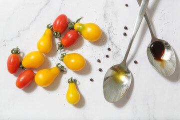 Summer salad ingredients - Freshly harvested cherry tomatoes, spoon of vinegar and olive oil, salt and pepper
