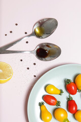 Summer salad ingredients - Freshly harvested cherry tomatoes, spoon of vinegar and olive oil, salt and pepper